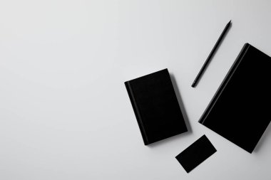 top view of black notebooks with business card and pencil on white tabletop for mockup clipart
