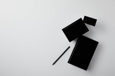 kartvizit ve kalem ile siyah Notebook üstten görünüm mockup için beyaz yüzeyi