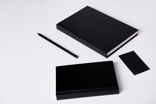 close-up shot of black notebooks  on white surface for mockup