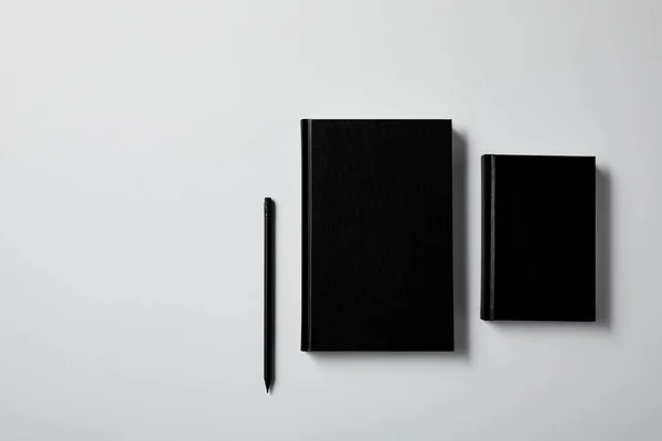 Vista Superior Cuadernos Negros Con Lápiz Superficie Blanca Para Maqueta —  Fotos de Stock