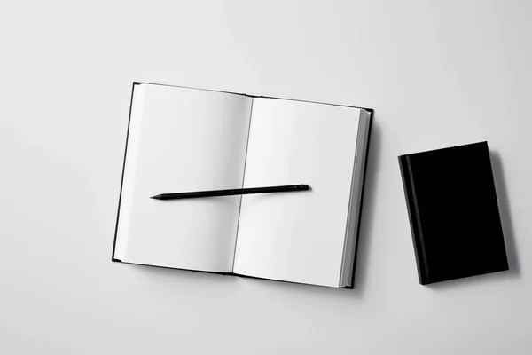 Vista Superior Cuadernos Negros Con Lápiz Superficie Blanca Para Maqueta —  Fotos de Stock