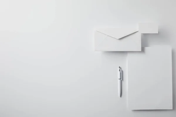 Bovenaanzicht Van Gelaagde Envelop Met Pen Papier Visitekaartje Witte Ondergrond — Stockfoto