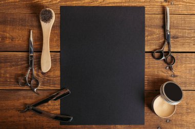 top view of professional barber tools and blank black card on wooden table   clipart