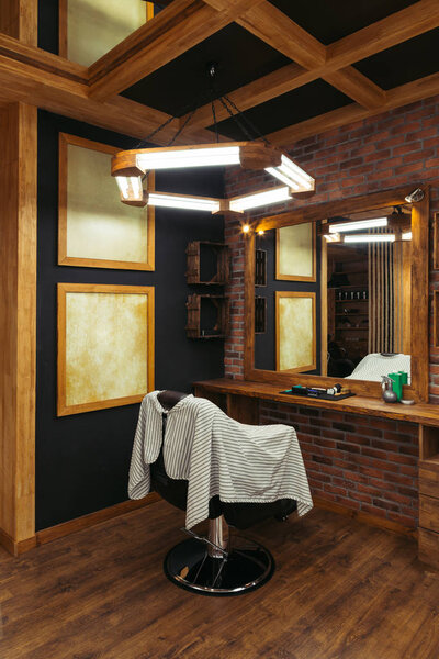 modern empty barbershop interior with chair, mirror and lamps