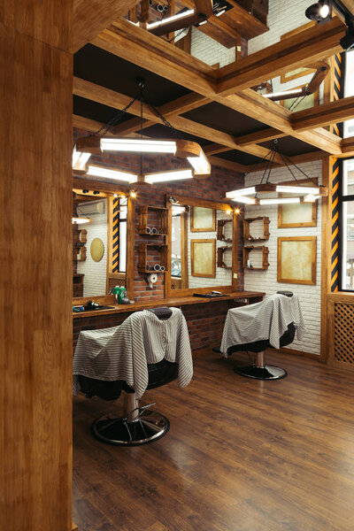 empty chairs and mirrors in modern barbershop 