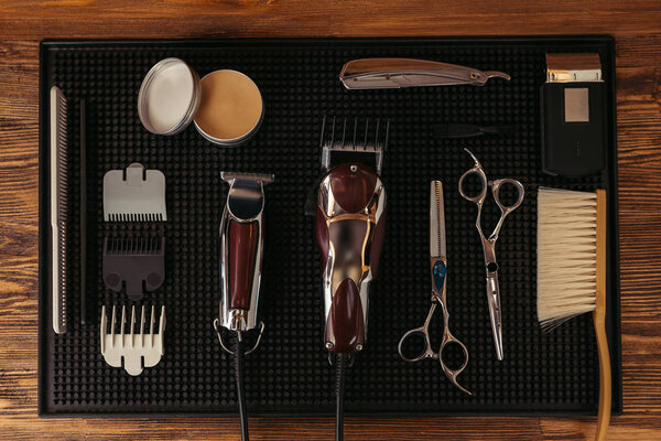 верхний вид набора различных профессиональных инструментов парикмахера в парикмахерской
 