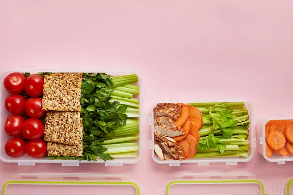 平躺与新鲜蔬菜和饼干安排在食物容器在粉红色隔离 — 图库照片