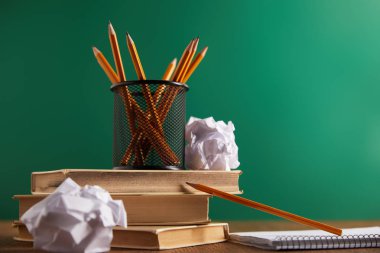 books, crumpled papers and pencils with green chalkboard on background clipart