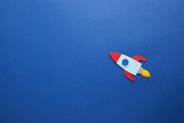 creative rocket on blue paper background