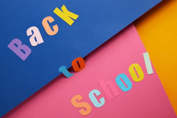 Flache Liege Mit Back School Schriftzug Auf Buntem Papierhintergrund — kostenloses Stockfoto