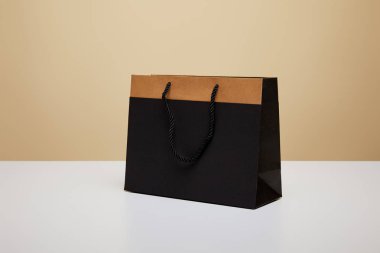 beyaz masa üzerinde bir siyah alışveriş çantası