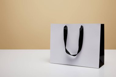 Beyaz tablo üzerinde bej izole bir beyaz alışveriş çantası