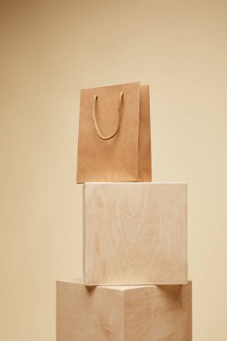 shopping bag on wooden cubes isolated on beige  clipart