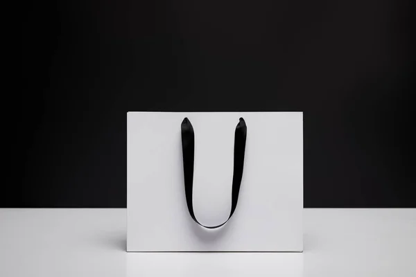 Egy Fehér Bevásárló Táska Fekete Elszigetelt Fehér Asztal — Stock Fotó