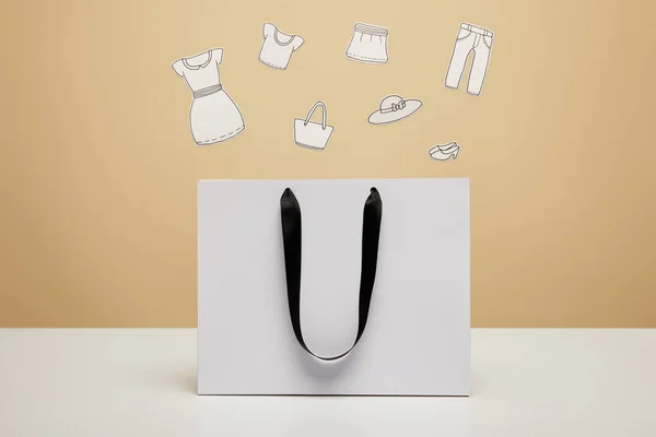 Pakaian Kertas Atas Tas Belanja Putih Atas Meja Putih Terisolasi — Stok Foto