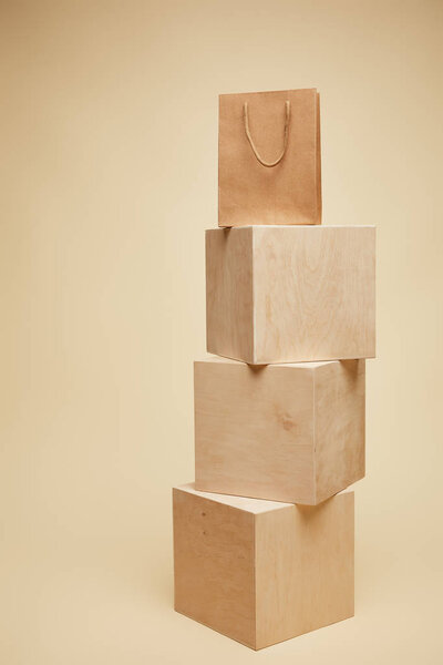 one shopping bag on wooden cubes isolated on beige 