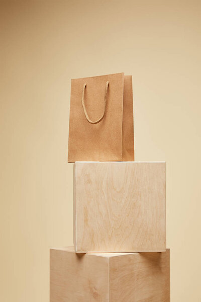shopping bag on wooden cubes isolated on beige 