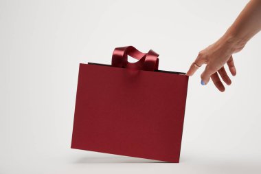 cropped image of woman touching burgundy shopping bag isolated on white clipart