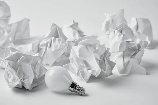 Close Shot Energy Saving Light Bulb Crumpled Papers White — Stock Photo, Image