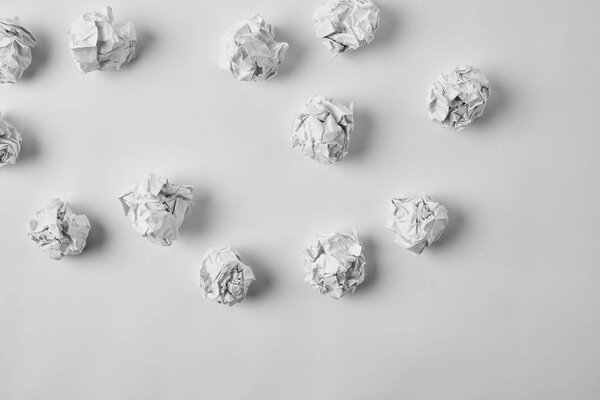 top view of spilled crumpled papers on white surface