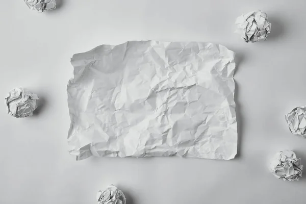 Beyaz Yüzey Üzerinde Buruşuk Kağıtlar Ile Çevrili Boş Hasarlı Kağıt — Stok fotoğraf