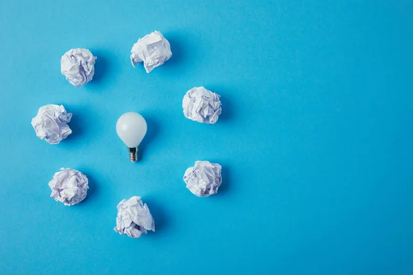 Top View Power Saving Light Bulb Surrounded Crumpled Papers Blue — Stock Photo, Image