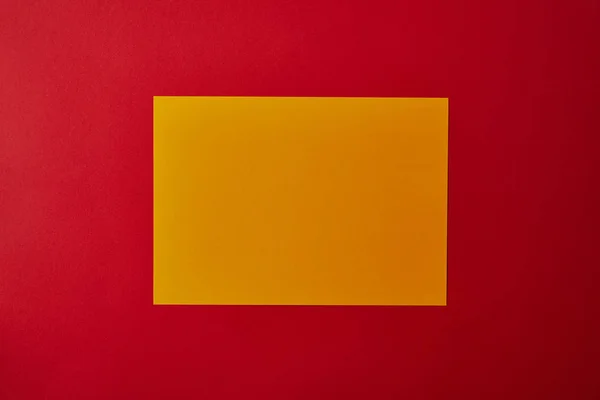 Blanco Geel Papier Rode Oppervlak Bovenaanzicht — Gratis stockfoto