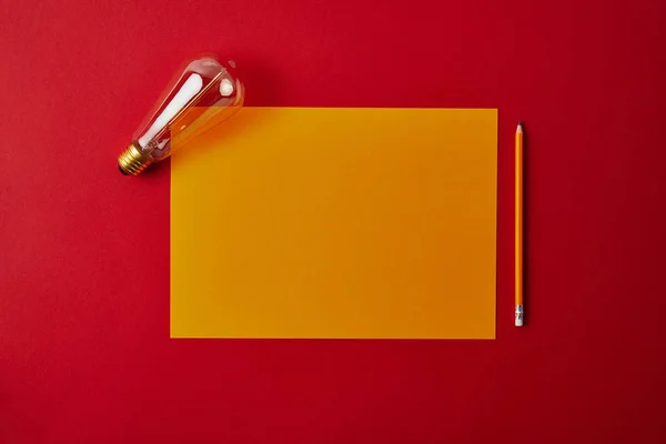 Top View Blank Yellow Paper Pencil Incandescent Lamp Red Surface — Stock Photo, Image