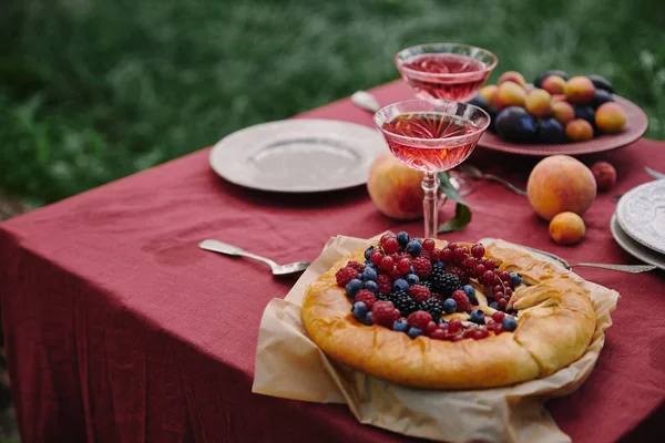 ベリーのパイと庭のテーブルでワインのグラス — ストック写真