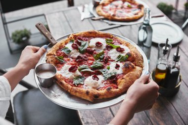 kadın taşıma plaka restoran masada hizmet için lezzetli pizza ile kadeh kırpılmış