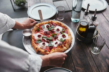 kadın taşıma plaka restoran masada hizmet için lezzetli pizza margherita ile kadeh kırpılmış
