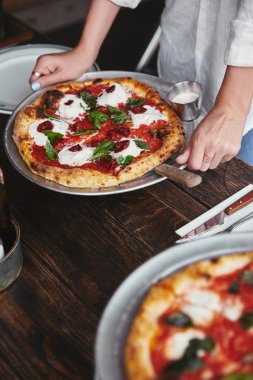 kadın lezzetli pizza ile plaka görüntüsünü kırpılmış