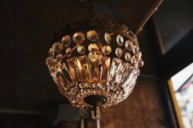 close-up shot of vintage chandelier hanging from ceiling of restaurant clipart