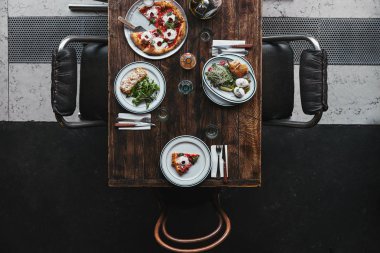 ahşap rustik tablo restoranda lezzetli İtalyan yemekleri ve içecekleri üstten görünüm