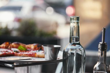 restoranda lezzetli pizza tepsisi ve şişe suyu yakın çekim vurdu