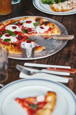 Trey'le üzerinde ahşap masa restoranda lezzetli pizza margherita, yakın çekim vurdu