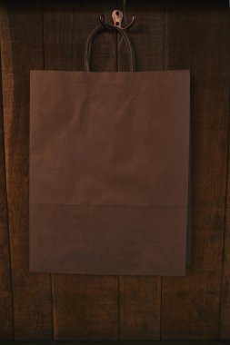 blank paper bag hanging on wooden wall clipart