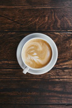 top view of cup of delicious coffee on rustic wooden table clipart