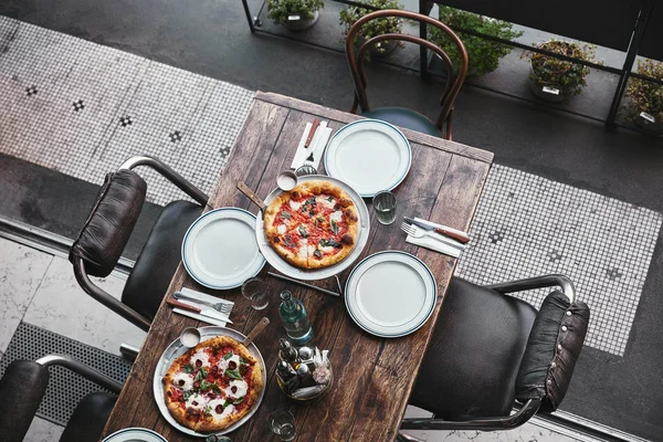 在餐厅托盘上的不同新鲜烘焙比萨饼的顶级视图 — 图库照片