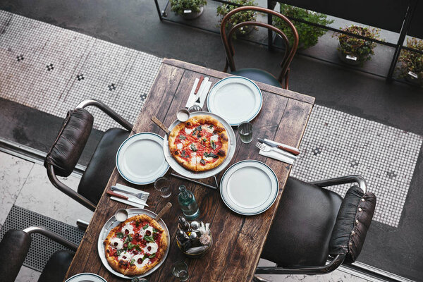 top view of different freshly baked pizza on trays at restaurant