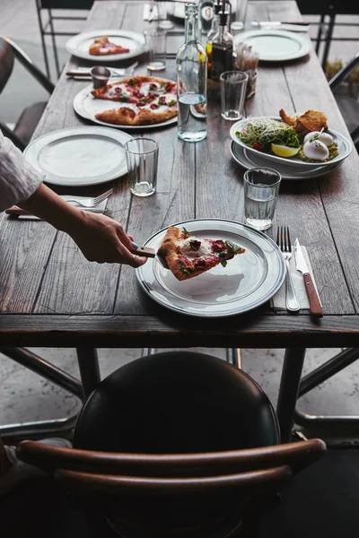 Обрізаний Знімок Жінки Подає Скибочки Смачної Піци Тарілці Ресторані — стокове фото