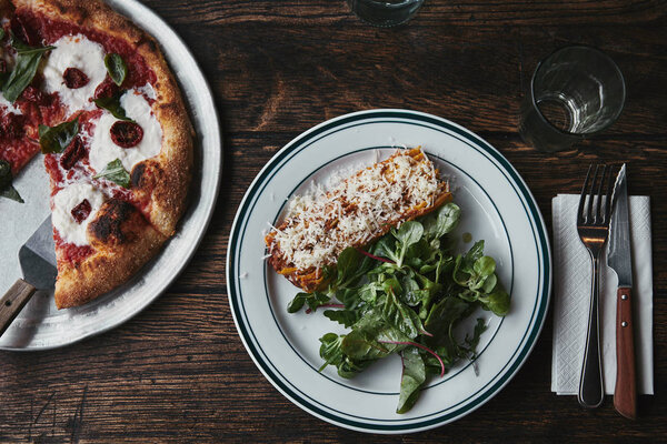 top view of freshly baked pizza and lasagne on wooden table 