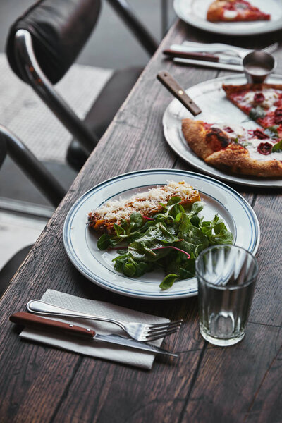 close-up shot of delicious pizza and lasagne on wooden table 