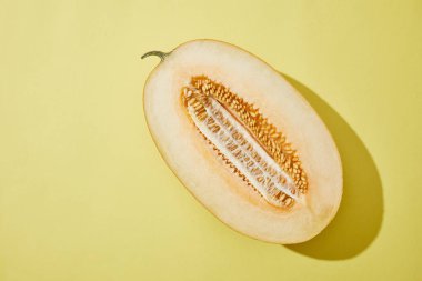 top view of fresh ripe halved melon on yellow background  clipart