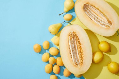 mavi ve sarı zemin üzerine tatlı Olgun kavun, armut, kayısı ve limon üstten görünüm