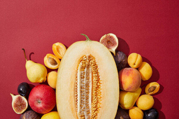 top view of various fresh ripe sweet fruits on red background