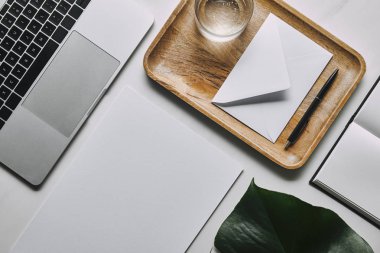 düz lay ile kağıt, zarf ve beyaz mermer zemin üstünde laptop ile iş şablonu