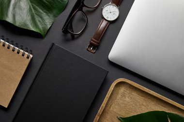 Defter ve laptop ile gözlük ile yat ve siyah arka plan üzerine izle