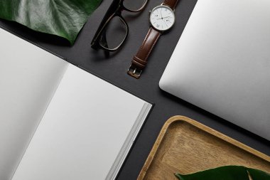 Açık defter ve laptop siyah arka plan üzerine düz yatıyordu şablonuyla