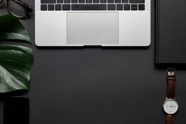 Siyah arka plan üzerine laptop ve iş aksesuarları ile kompozisyon